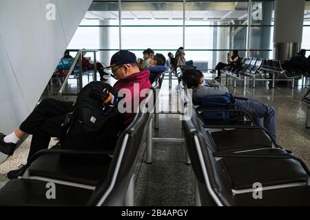 Hongkong, China. März 2020. Reisende, die Gesichtsmasken als Vorsichtsmaßnahme gegen den Ausbruch von Coronavirus tragen, ruhen im Wartebereich am internationalen Flughafen Hongkong.Da sich das Coronavirus (Covid-19) weiterhin auf der ganzen Welt ausbreitet, haben viele Länder die Reisebeschränkungen verschärft. Credit: Sopa Images Limited/Alamy Live News Stockfoto