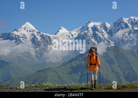 Tourist vor Hochgebirge Hintergrund. Frau liegt auf der Alpenwiese. Stockfoto