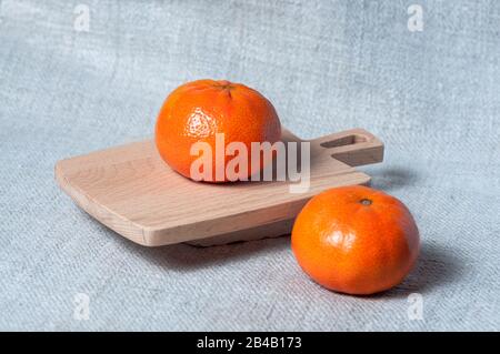 Mandarinen auf einem kleinen Holzbrett. Tropische Früchte. Stockfoto
