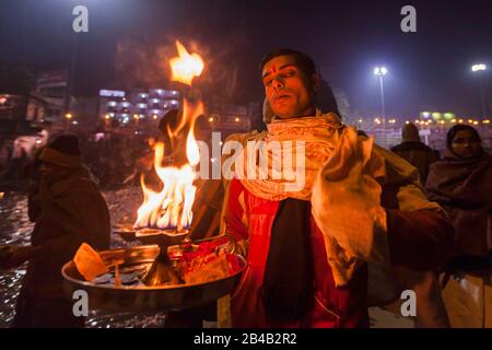 Indien, Uttarakhand, Haridwar, heilige Stadt des hinduismus, Kumbh Mela Hindu-Pilgerreise, Har Ki Pauri Ghat, heiliger Mann segnet Pilger nach aarti, Abendgebet Stockfoto