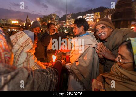 Indien, Uttarakhand, Haridwar, heilige Stadt des hinduismus, Kumbh Mela Hindu-Pilgerreise, Har Ki Pauri Ghat, heiliger Mann segnet Pilger nach aarti, Abendgebet Stockfoto