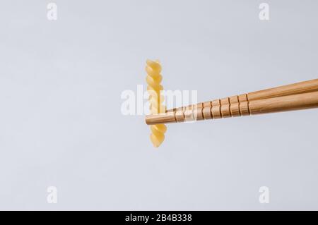 Chinesische Essstäbchen mit Teiggirandol auf weißem Hintergrund. Stockfoto