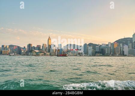 Hongkong, CHINA - CIRCA JANUAR 2019: WAN Chai und Central vom Victoria Harbour aus gesehen in der Dämmerung. Stockfoto