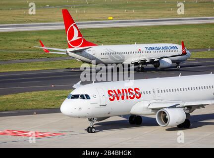 Düsseldorf, Nordrhein-Westfalen, Deutschland - die Schweizer Flugzeuge Airbus A320-214 und Turkish Airlines Boing 737-8F2 warten auf den Abflug in Duesseld Stockfoto