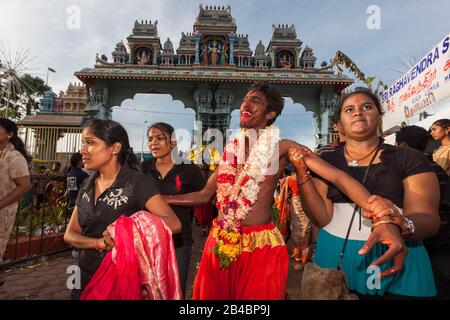 Malaysia, Selangor State, Batu Caves, Hindu-Festival Thaipusam Procession, junger Mann in Trance, der Unterstützung von seinen Schwestern erhält Stockfoto