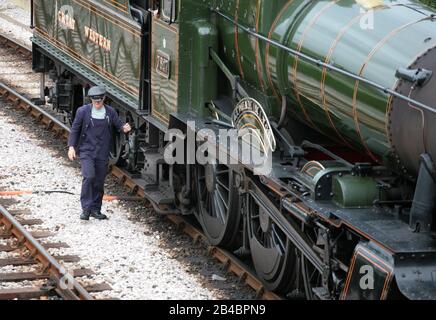 GWR 'Manor'-Klassenlok Nr. 7827 'Lydham Manor' im Kingswear Station auf der Dartmouth Steam Railway: Feuermann alcht aus dem Taxi: Devon, England Stockfoto