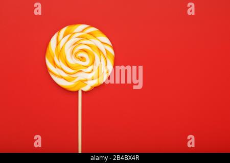 Farbenfroher runder Lollipop, auf pinkfarbenem, mintblau, rotem Hintergrund. Minimales Konzept mit Kopierraum. Süßwaren, Süßigkeiten Stockfoto