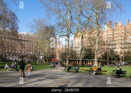 Menschen, die an einem sonnigen Tag im märz am Russell Square London spazieren; Russell Square, Bloomsbury, London Borough of Camden, London UK Stockfoto