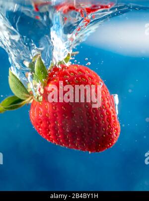 Erdbeere fiel in tiefes Wasser Stockfoto
