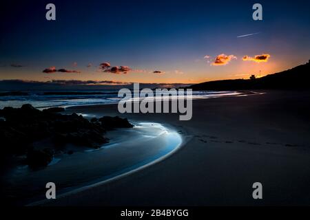 Ruhiger und entspannter malerischer Strandplatz bei Sonnenuntergang mit farbigem Himmel im Hintergrund - Seeufer im Freien - Freiheit und Lifestyle Nachtbild mit niemandem da Stockfoto