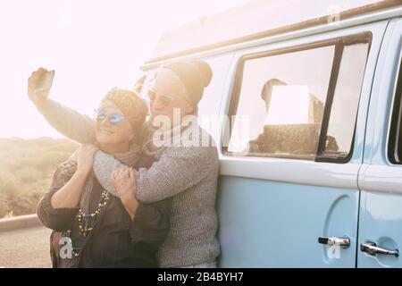 Reise- und Alternative-Leute-Urlaubskonzept für Senioren im Ruhestand Lifestyle-Paare, die selfie Bild für soziale Medien machen - Oldtimer im Hintergrund - Sunset Sunlight und Forever Konzept Stockfoto