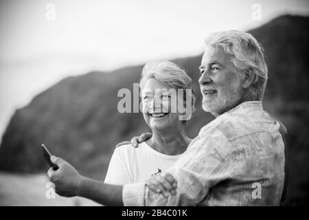 Wunderschönes romantisches Porträt des älteren glücklichen Paares lächelt und umarmt eachother mit Liebe - für immer zusammen Konzept und aktiver älterer glücklicher Lebensstil - weißer klarer Hintergrund und lächelnde Menschen Stockfoto