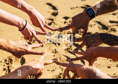 Team- und Kooperationsfreundschaftskonzept mit Gruppe kaukasischer junger Hände, die unter dem sonnigen Sommertag Siegeszeichen machen - Freunde und Jugendliche vereint für immer Stockfoto