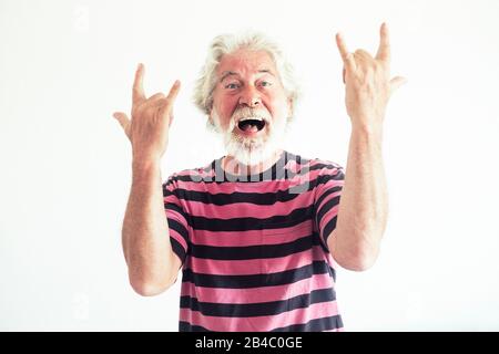 Ältere Leute kaukasischer Mann machen Rock'n Roll-Schilder mit verrückten lustigen Ausdrucks-Porträt - fröhlicher reifer, pensionierter Lebensstil hat Spaß ohne Limit Alter - weißer Hintergrund Studio Shot Stockfoto