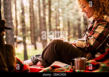 Reisen Alternative und wanderlust Lifestyle-Leute - schöne junge Frau setzt sich im Hintergrund in einem Zelt mit malerischem Wald nieder - Abenteuer- und Umweltkonzept für freie Hüftweibchen Stockfoto