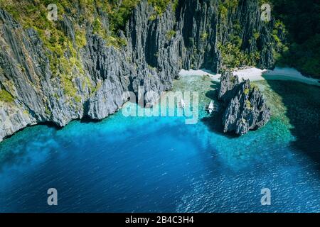 El Nido, Palawan, Philippinen. Luftaufnahme von banca-booten, umgeben von Karstfelsen am Strand von Secret Lagoon. Stockfoto