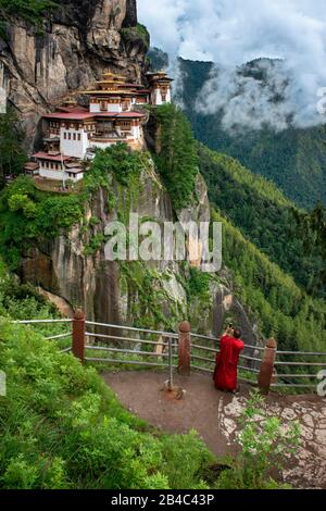 Mönch im Taktsang Goemba oder Tigers nisten Kloster im Paro-Tal, Bhutan, Asien. Das Kloster Paro Taktsang oder Taktsang Palphug und die Tiger-Nest sind es Stockfoto