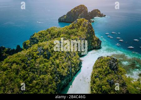 Luftdrone Blick auf den Eingang zur flachen tropischen großen und Kleinen Lagune, die von Touristen auf Kajaks erkundet wird, die von zerklüfteten Kalkkarstklippen umgeben sind. El Nido, Palawan Philippinen. Stockfoto