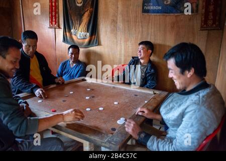Männer, die in Lobesa-Dorf Punakha spielen, spielen ein Spiel auf dem Spielbrett. Dies ist ein sehr beliebtes Spiel auf dem indischen Subkontinent. Stockfoto