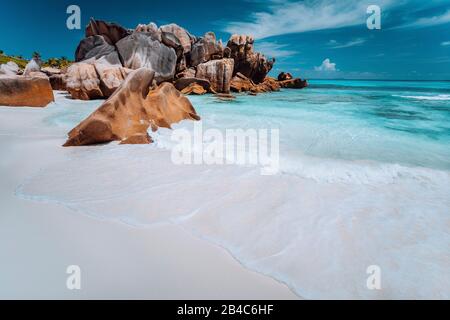 Granit Felsen, Geröll, perfekte weißer Sand, türkises Wasser, blauer Himmel. Paradise Beach Anse Cocos auf die Seychellen. Ferienhäuser Hintergrund. Stockfoto
