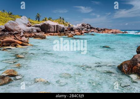 Anse Cocos Beach, Seychellen. Blaue türkisfarbene Lagune und Felsbrocken aus Granit. Blauer Himmel im Hintergrund. Urlaubsreisekonzept. Stockfoto