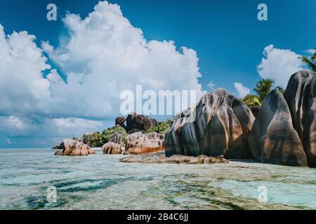 Berühmte Granit-Felsbrocken in der Lagune mit flachem Meerwasser und weißer Wolkenscape am fantastischen tropischen Strand von Anse Source D'Argent, La Digue Seychelles. Luxuriöses exotisches Reisekonzept. Stockfoto