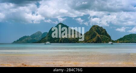Panoramaszenerie vom Corong Corong Beach, El Nido, Palawan, Philippinen. Landschaft mit Bergküste, Bucht und Jachtboot vor Anker. Stockfoto