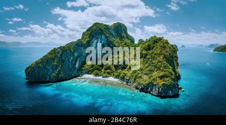 Luftdrone Panoramabild des tropischen Paradiesepos Entalula Island. Felsige Berge aus Karstkalk umschließen die blaue Lagune mit wunderschönem Korallenriffe. Stockfoto