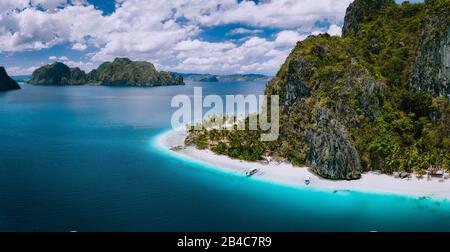 El Nido, Palawan, Philippinen. Luftdrohne vom Strand Ipil auf der Insel Pinagbuyutan. Fantastischer weißer Sand, Kokospalmen und türkisblaues Meerwasser. Stockfoto