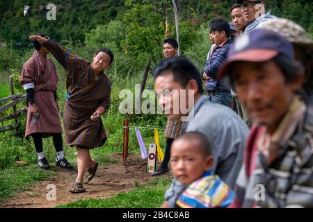 Männer spielen in Khuru wagt traditionelle bhutanische Sportart, in Paro Bhutan große Darts ins Freie zu werfen Stockfoto