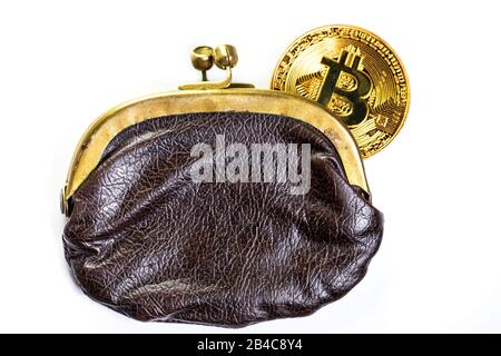 Eine Goldmünze der Bitcoin-Kryptokurrency liegt in einer Vintage-Brieftasche auf weißem Hintergrund Stockfoto