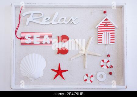 Rot-weißes maritimes Stillleben mit Natur- und Dekorationsobjekten in einer Holzkiste Stockfoto