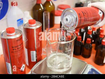 Leipzig, Deutschland. März 2020. In einem Labor der Rosenapotheke am Auwald in Leipzig füllt ein Apotheker ein Glas mit Isopropylalkohol für eine Lösung zur hygienischen Händededesinfektion nach WHO-Empfehlungen. Aufgrund der großen Nachfrage nach diesen Desinfektionsmitteln produzieren die Mitarbeiter diese Desinfektionslösung für die Hände aus dem 2-Propanol (Alkohol), Wasserstoffperoxid, Glycerol und gereinigtem Wasser, das vom Großhändler seit Donnerstag, dem 05.03.2020 geliefert wird. Kredit: Waltraud Grubitzsch / zb-Zentralbild / dpa / Alamy Live News Stockfoto