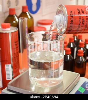 Leipzig, Deutschland. März 2020. In einem Labor der Rosenapotheke am Auwald in Leipzig füllt ein Apotheker ein Glas mit Isopropylalkohol für eine Lösung zur hygienischen Händededesinfektion nach WHO-Empfehlungen. Aufgrund der großen Nachfrage nach diesen Desinfektionsmitteln produzieren die Mitarbeiter diese Desinfektionslösung für die Hände aus dem 2-Propanol (Alkohol), Wasserstoffperoxid, Glycerol und gereinigtem Wasser, das vom Großhändler seit Donnerstag, dem 05.03.2020 geliefert wird. Kredit: Waltraud Grubitzsch / zb-Zentralbild / dpa / Alamy Live News Stockfoto