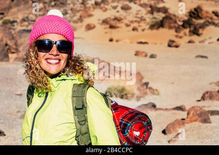 Fröhliche junge kaukasische Frau lächelt und genießt das Trekking im Freien mit Berg und Wüste im Backgorund -c onkept von Reisen und Campen frei genießen alternativen Lebensweg Stockfoto