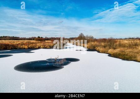 Schnee auf dem Eis auf einem kleinen See in Wiesmoor Stockfoto