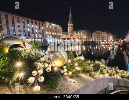 Hamburg - Weihnachtsdekoration mit Goldkugeln, Licht und Blick auf Rathaus und alster in Deutschland. Stockfoto