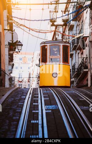 Die gelbe Standseilbahn Gloria in Lissabon fährt die Straße hinunter. Lissabon. Portugal, Europa, die Westseite der Avenida da Liberdade verbindet die Innenstadt mit Bairro Alto. Stockfoto