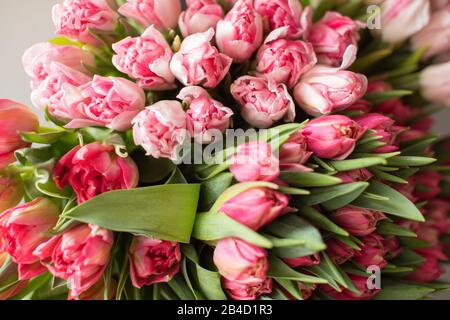 Nahaufnahme Großer Wunderschöner Blumenstrauß aus gemischten Tulpen. Blumenhintergrund und Hintergrundbild. Blumengeschäft Konzept . Wunderschöner, frisch geschnittener Blumenstrauß. Blumen Lieferung Stockfoto