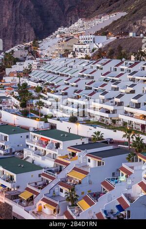Spanien, Kanarische Inseln, Teneriffa, Los Gigantes, Hillside Apartments und Steilküsten, Erhöhte Ansicht, Dämmerung Stockfoto