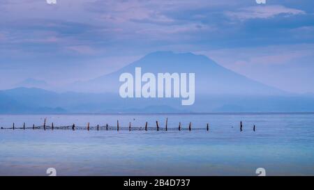 Schöner Blick am Abend auf St. Agung Vulcano auf Bali von der Insel Nusa Penida, Net vor einigen Wolken im Hintergrund. Stockfoto