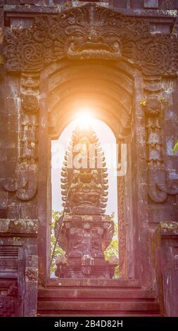 Tor im Tempel des Pura Besakih-Tempels mit Hindu-Altar in Sonnenlicht-Leuchtreklammen. Stockfoto