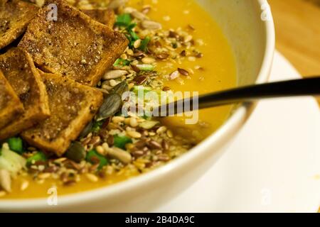 Cremefarbene Suppe mit Croutons und Dill auf weißer Serviette, horizontale Nahaufnahme Stockfoto