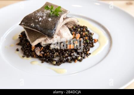 Forellenfilets mit Linsen auf weißem Polat Stockfoto