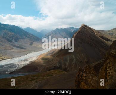 Der Fluss Spiti mäandert an einem schönen Sommertag in der Nähe von Kada, Himachal Pradesh, Indien, durch das Tal der Spiti, das von hohen Gipfeln des Himalayas flankiert wird. Stockfoto