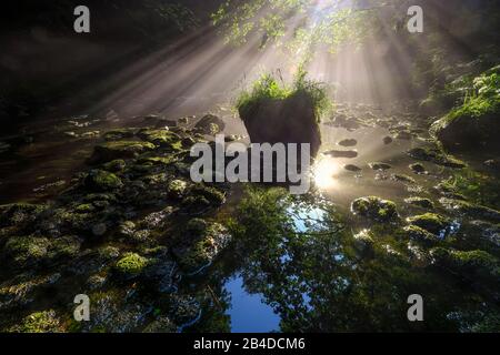 Sonnenauf- und Nebelfäden über dem Wasser eines Flusses Stockfoto