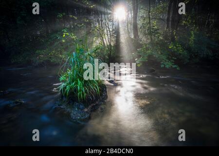 Sonnenauf- und Nebelfäden über dem Wasser eines Flusses Stockfoto