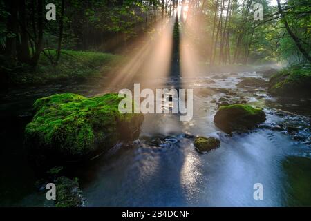 Sonnenauf- und Nebelfäden über dem Wasser eines Flusses Stockfoto