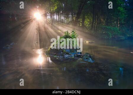 Sonnenauf- und Nebelfäden über dem Wasser eines Flusses Stockfoto