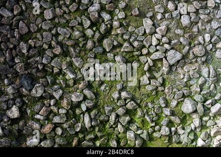 Hintergrund der alten, rauhen, moosigen Steinmauer Stockfoto